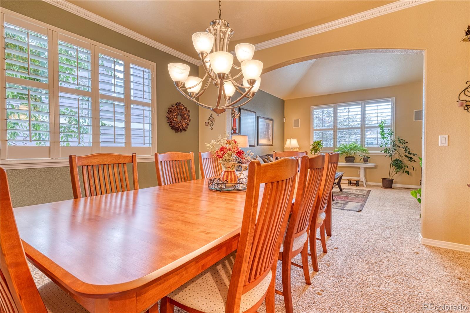 6378 Umber Circle Arvada, CO 80403 - Photo 19 of 50 a dining room with wooden floor a chandelier a glass table and chairs