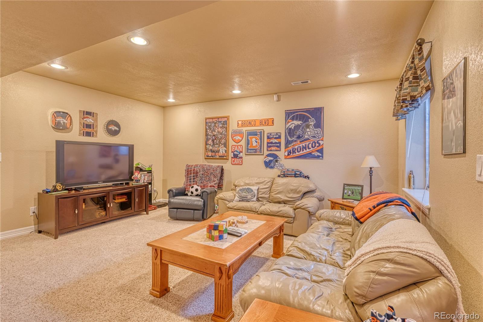 6378 Umber Circle Arvada, CO 80403 - Photo 34 of 50 a living room with furniture and a flat screen tv