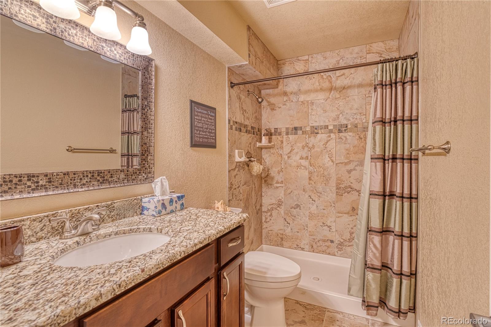 6378 Umber Circle Arvada, CO 80403 - Photo 40 of 50 a bathroom with a granite countertop sink toilet and shower
