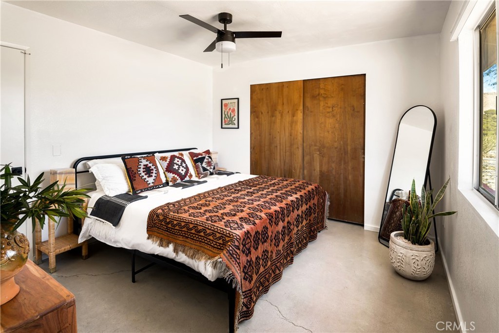 7566 Shawnee Trail Yucca Valley, CA 92284 - Photo 17 of 28 a bedroom with a bed and a large window