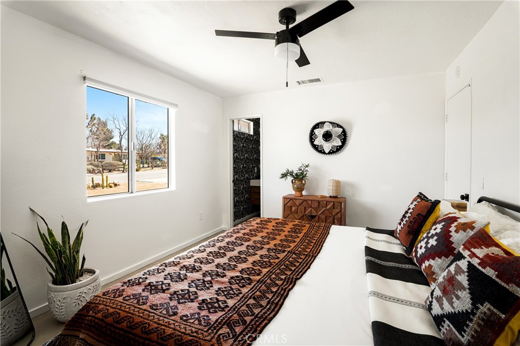 7566 Shawnee Trail Yucca Valley, CA 92284 - Photo 19 of 28 a bedroom with bed and a window