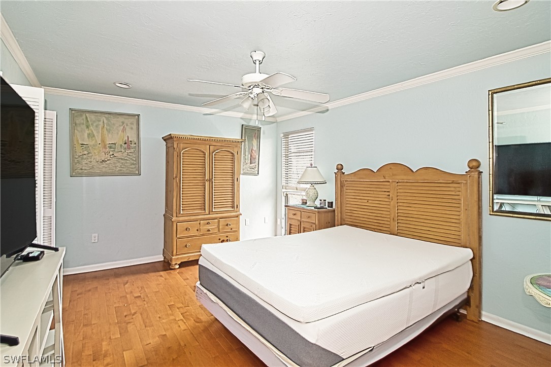 954 Sand Castle Road Sanibel, FL 33957 - Photo 20 of 29 a bedroom with a bed dresser and a flat screen tv
