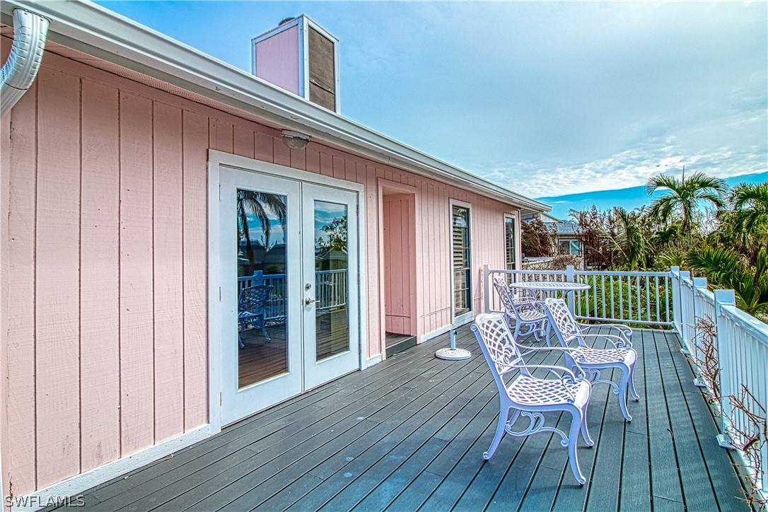 954 Sand Castle Road Sanibel, FL 33957 - Photo 3 of 29 a view of a deck with table and chairs and wooden floor