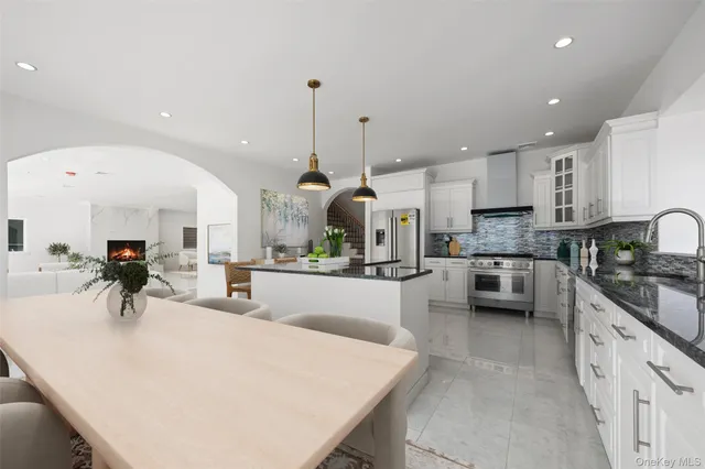 a kitchen with stainless steel appliances kitchen island granite countertop a stove a sink a oven and a view of living room view