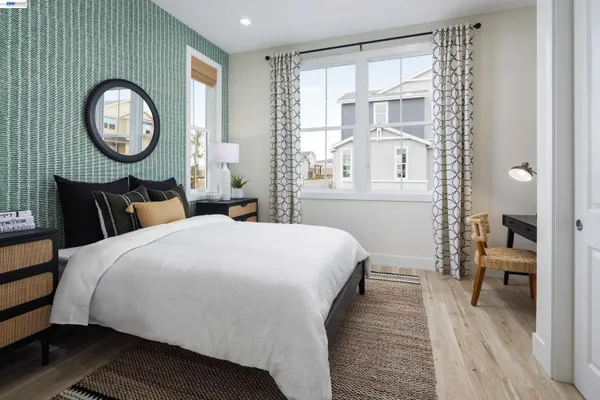 a bedroom with a bed mirror and a window