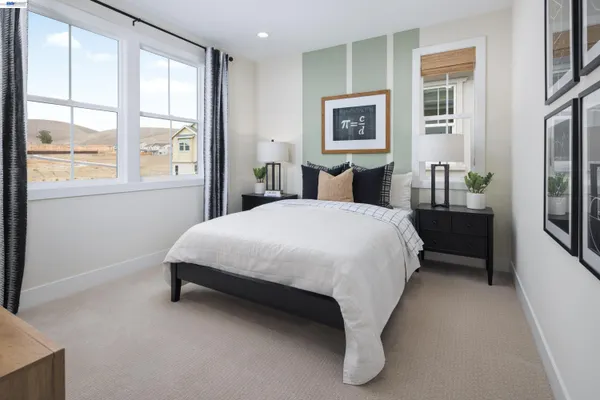 a bed sitting in a bedroom next to a window