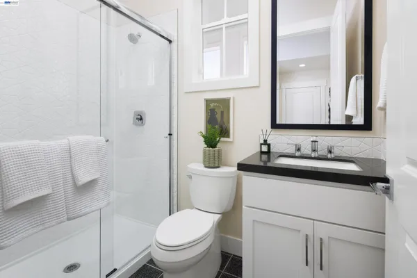 a bathroom with a granite countertop sink toilet and shower