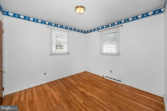 a view of a room with wooden floor and windows