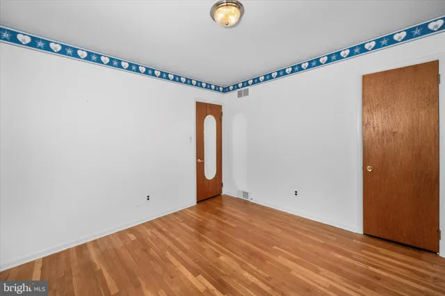 a view of a room with wooden floor and white walls