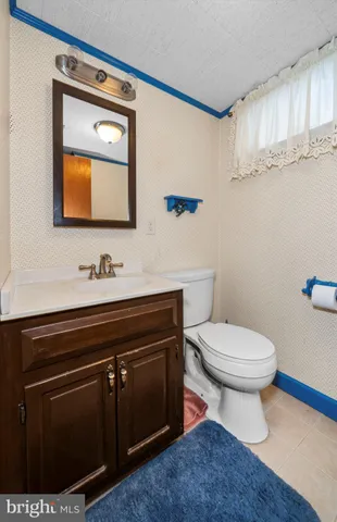 a bathroom with a toilet a sink and mirror