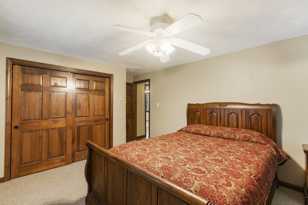138 Lincoln Road Sutton, MA 01590 - Photo 20 of 35 a bedroom with a large bed and a chandelier