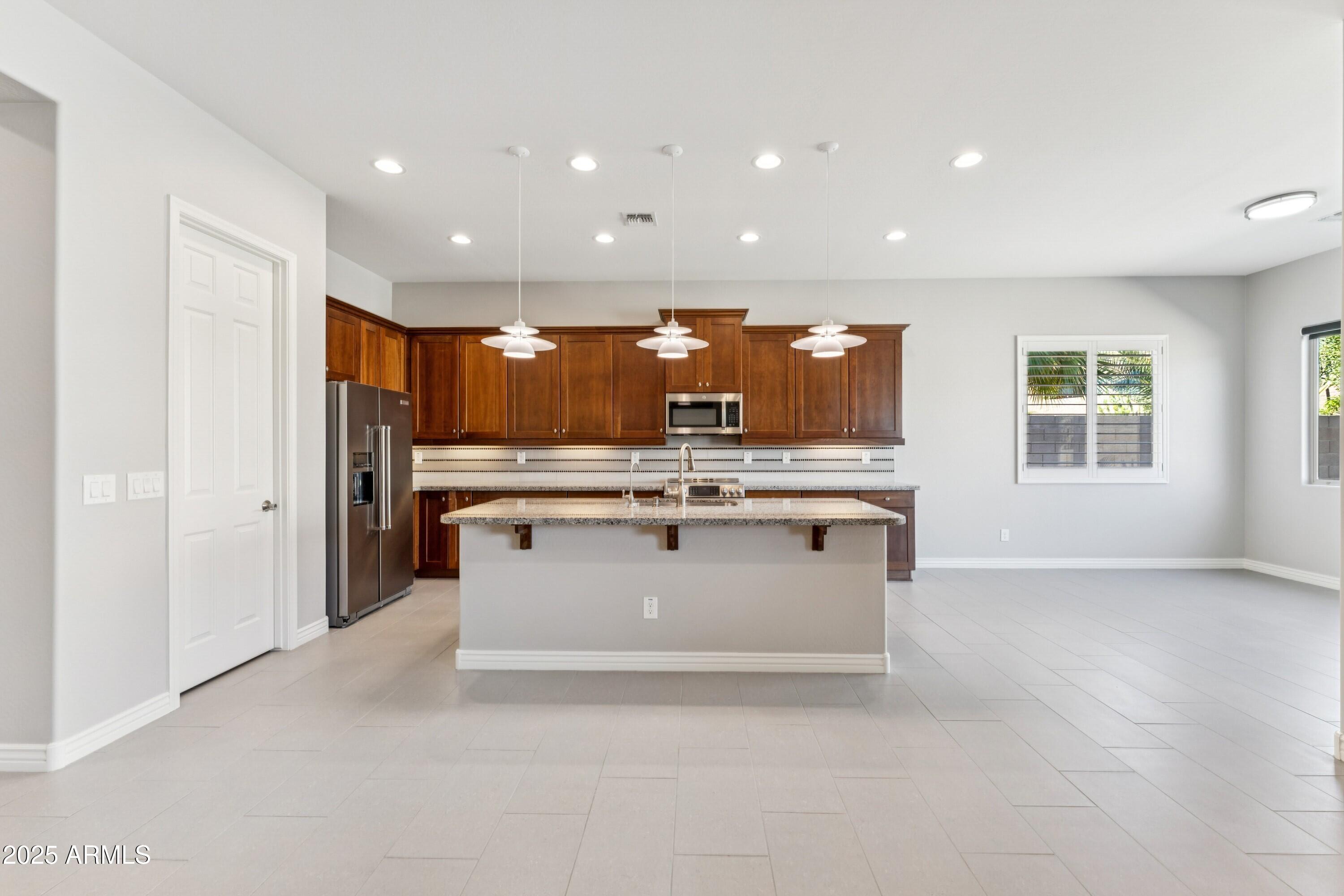 9916 West Redbird Road Peoria, AZ 85383 - Photo 13 of 96 a view of kitchen with stainless steel appliances granite countertop a stove and a sink