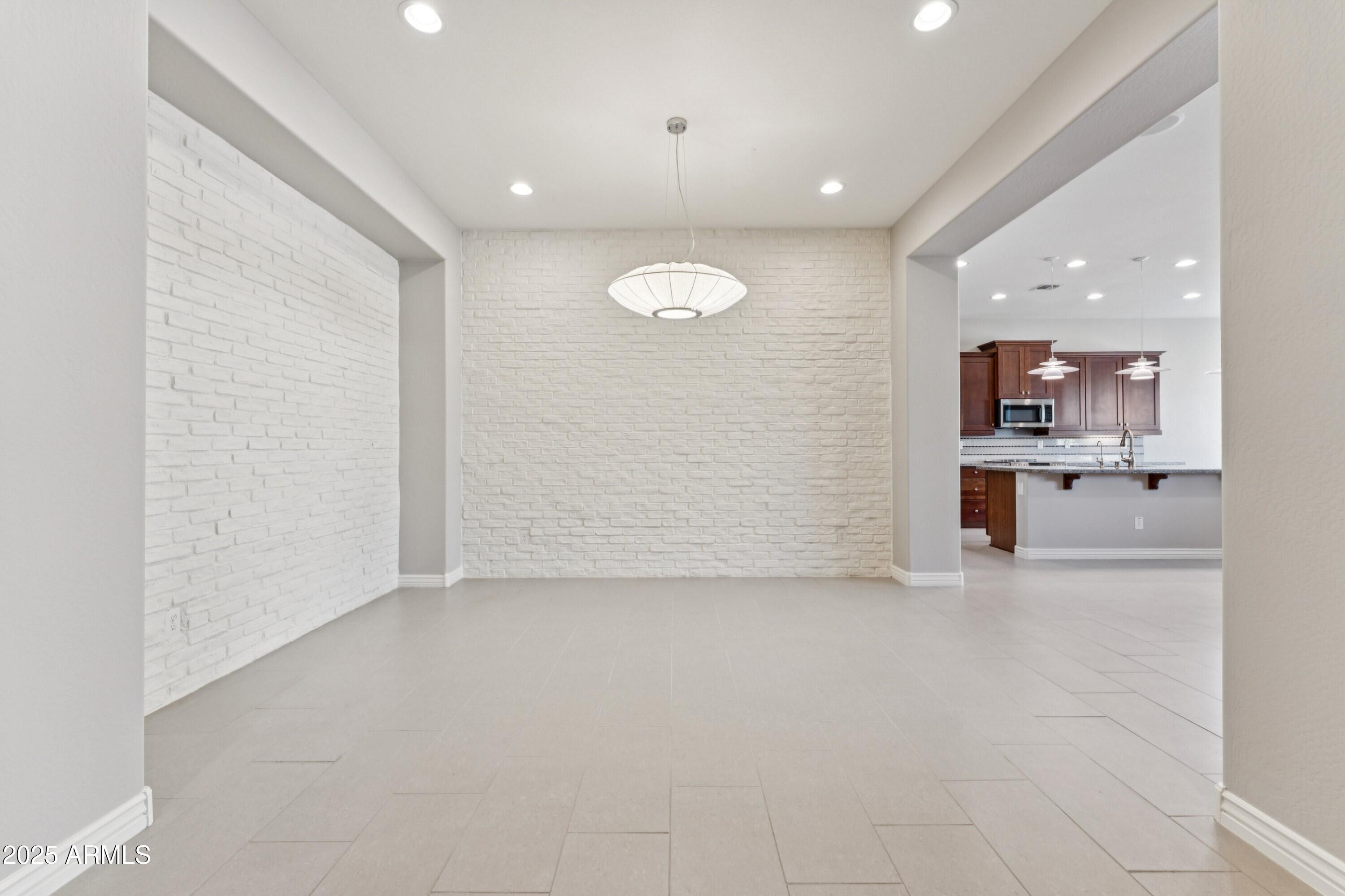 9916 West Redbird Road Peoria, AZ 85383 - Photo 15 of 96 an empty room with a kitchen and a sink