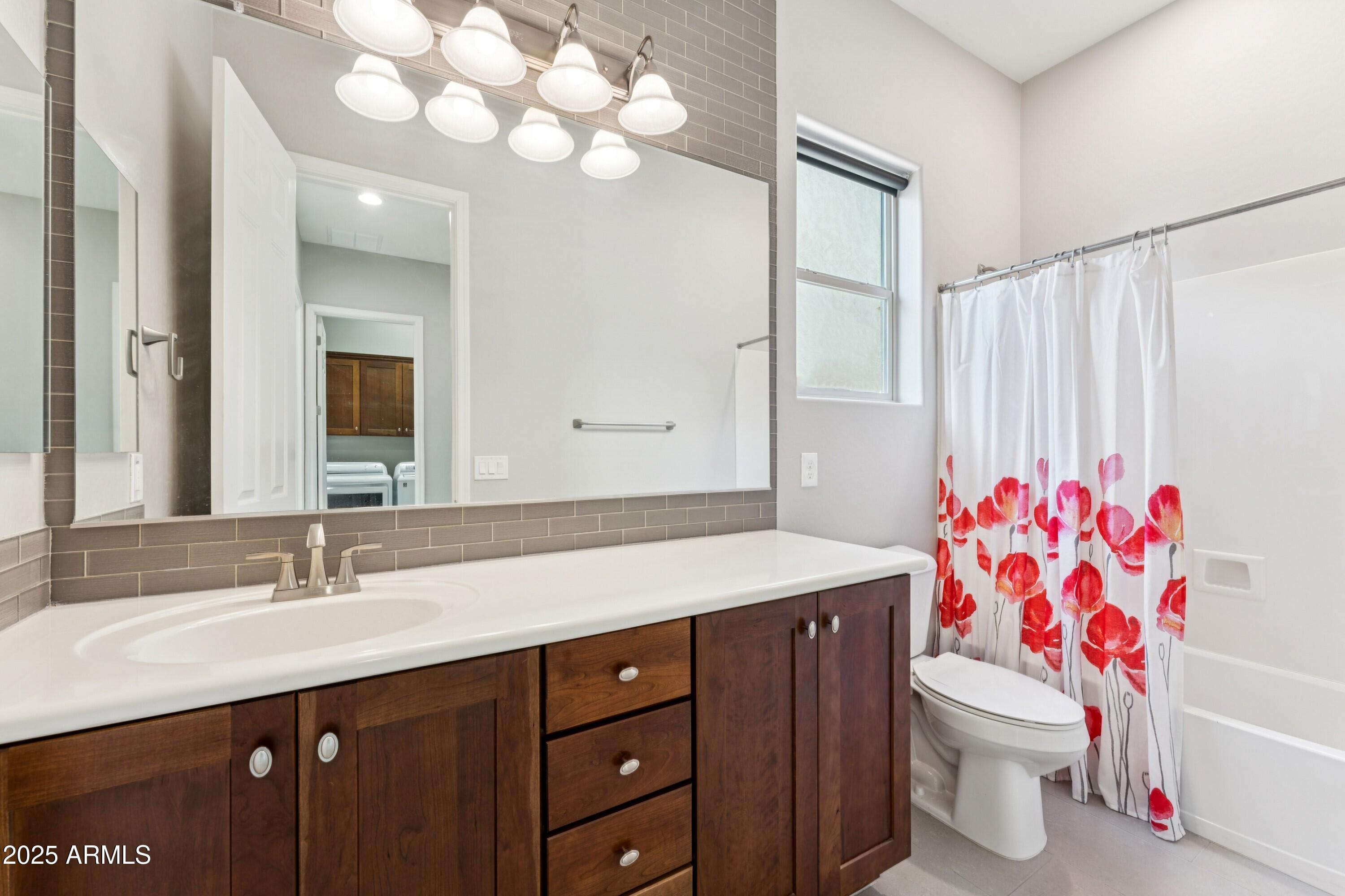 9916 West Redbird Road Peoria, AZ 85383 - Photo 32 of 96 a bathroom with a sink vanity mirror and toilet