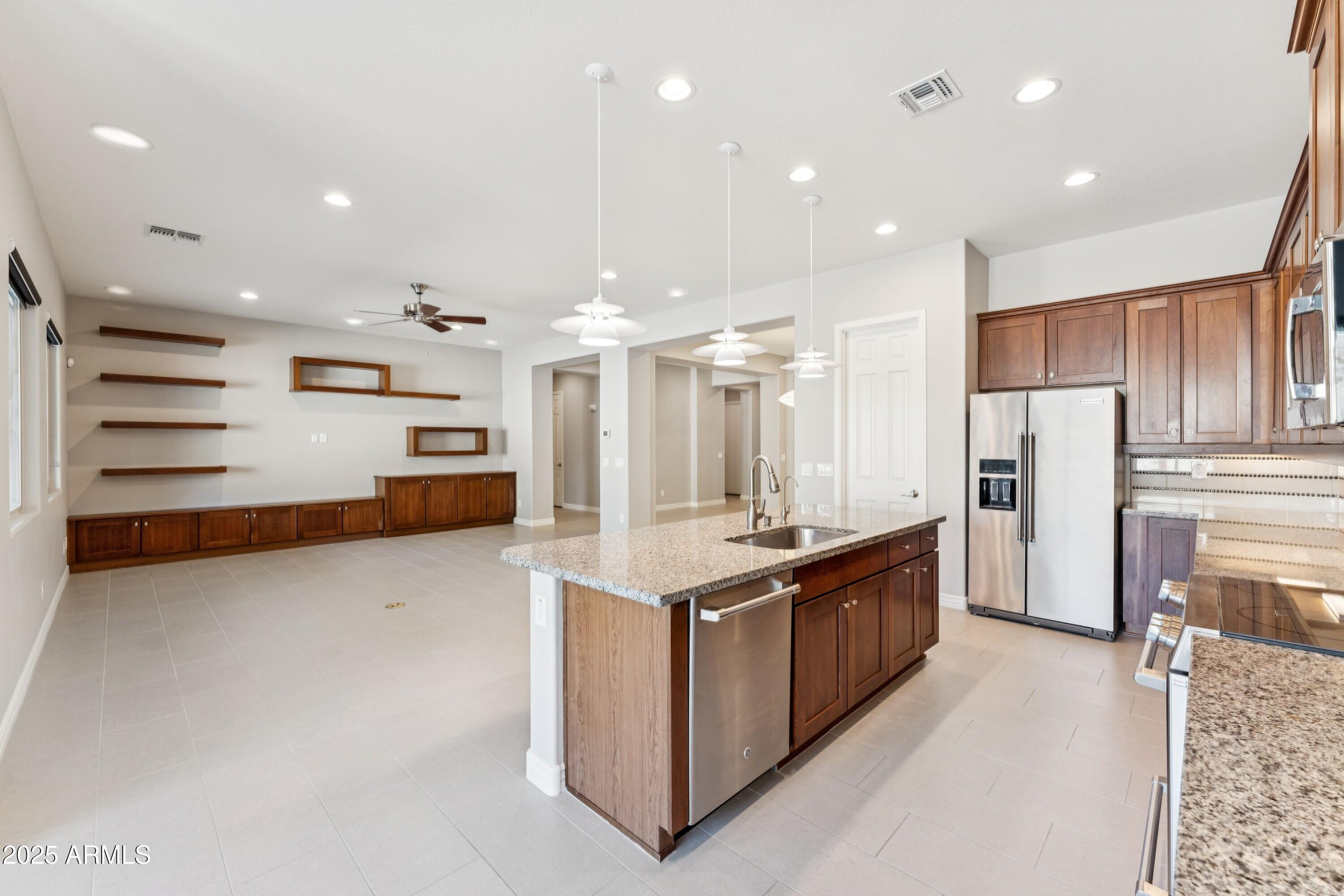 9916 West Redbird Road Peoria, AZ 85383 - Photo 9 of 96 a kitchen with stainless steel appliances granite countertop a refrigerator and a stove