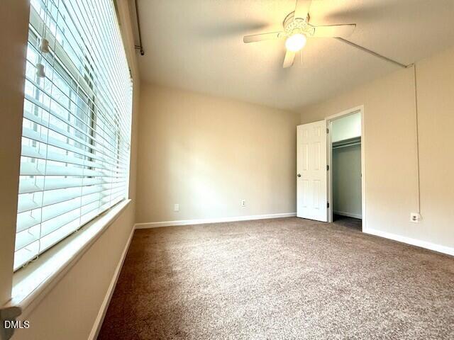 5800 Falls Of Neuse Road, Unit A Raleigh, NC 27609 - Photo 19 of 32 an empty room with chandelier fan and windows