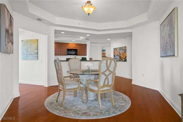 a dining room with furniture a chandelier and wooden floor