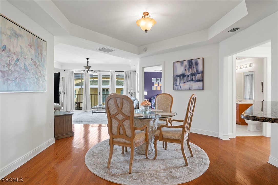 2745 First Street, Unit 2306 Fort Myers, FL 33916 - Photo 12 of 31 a dining room with furniture a chandelier and wooden floor