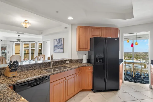 a living room with stainless steel appliances furniture a dining table and kitchen view