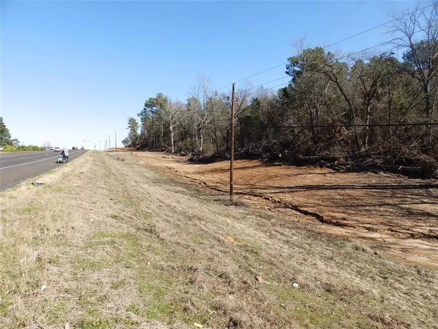 a view of dirt field with trees in the background