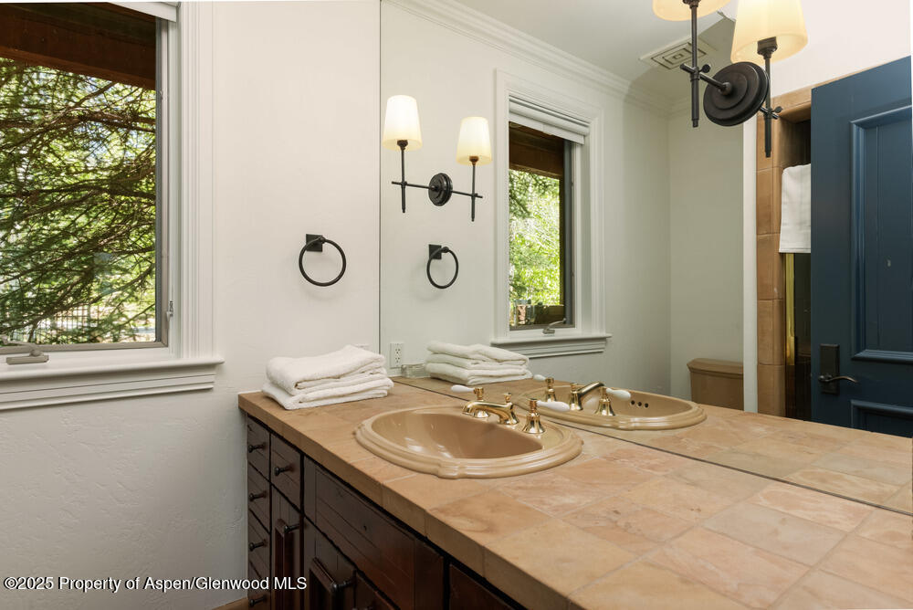 74 Pfister Drive, Unit 101 Aspen, CO 81611 - Photo 13 of 24 a bathroom with a granite countertop sink and a mirror