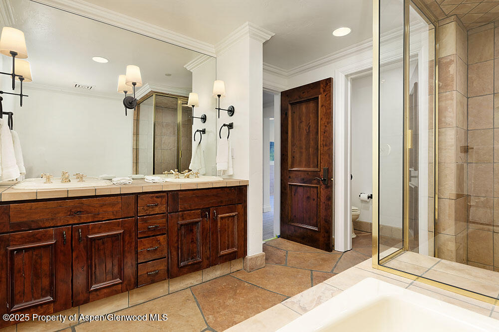 74 Pfister Drive, Unit 101 Aspen, CO 81611 - Photo 15 of 24 a spacious bathroom with a granite countertop sink mirror and shower