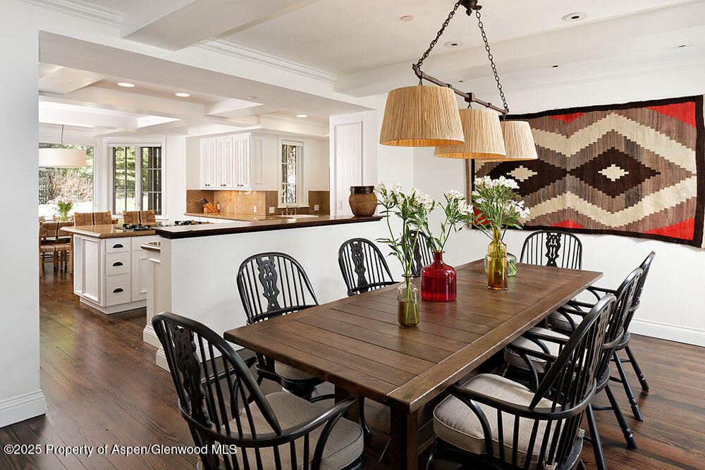 74 Pfister Drive, Unit 101 Aspen, CO 81611 - Photo 6 of 24 a view of a dining room and livingroom with furniture a rug a chandelier and wooden floor