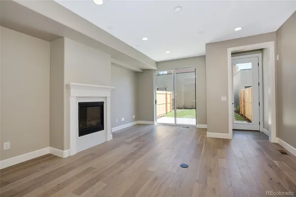 a view of a livingroom with wooden floor and a fireplace