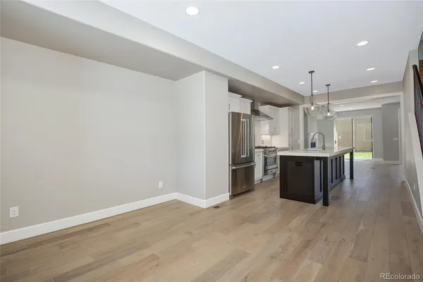 a kitchen with stainless steel appliances kitchen island granite countertop a refrigerator and a sink