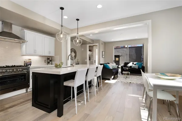 a living room with stainless steel appliances kitchen island granite countertop furniture and a wooden floor