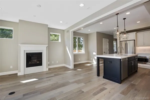 a large kitchen with a fireplace and a wooden floor