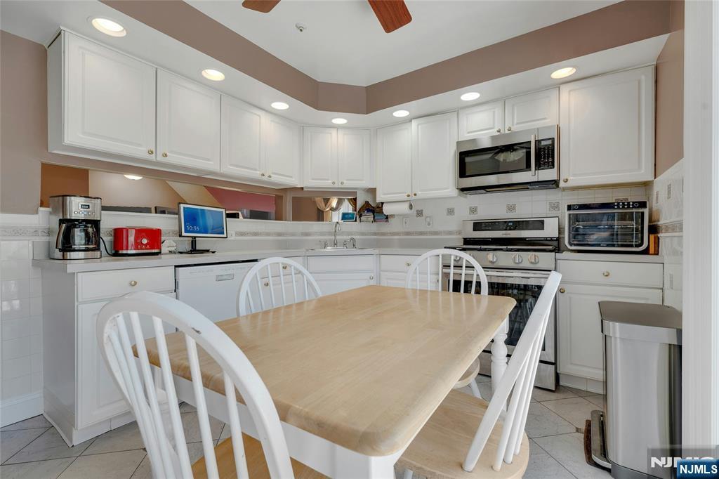 72 Marrow Street, Unit 3101 Newark, NJ 07103 - Photo 9 of 20 a kitchen with stainless steel appliances granite countertop a refrigerator a stove top oven a sink dishwasher and white cabinets with wooden floor