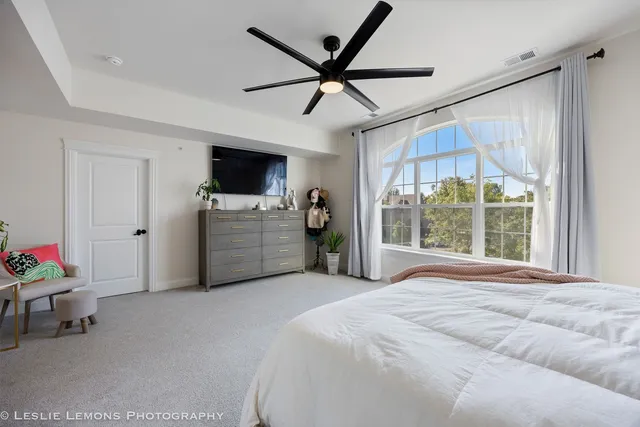 a bedroom with a bed and a large window
