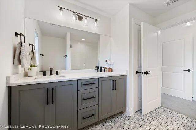a bathroom with a double vanity sink mirror and