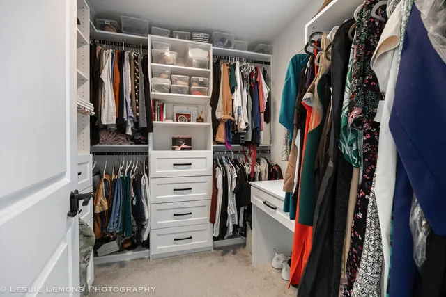 a view of walk in closet with clothes