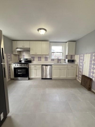 5 Alcott Street, Unit 2 Boston, MA 02134 - Photo 4 of 14 a kitchen with stainless steel appliances a stove sink and cabinets