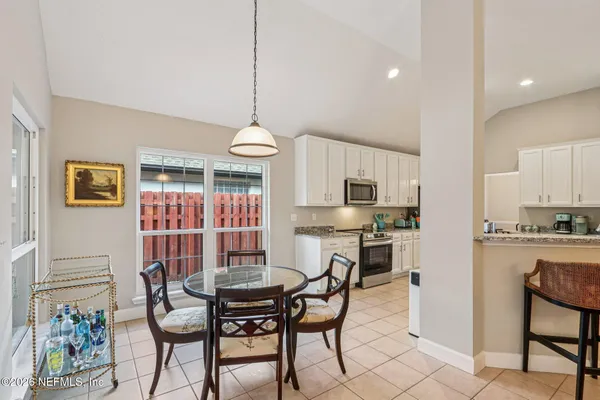 a dining room with furniture a chandelier and wooden floor