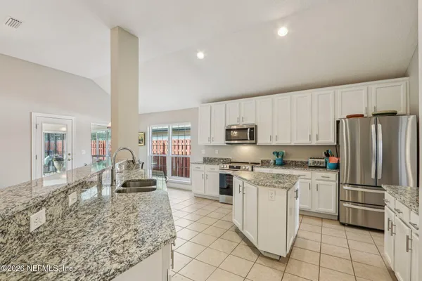a kitchen with stainless steel appliances granite countertop a sink and a refrigerator