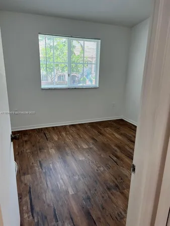 a view of a room with wooden floor and window