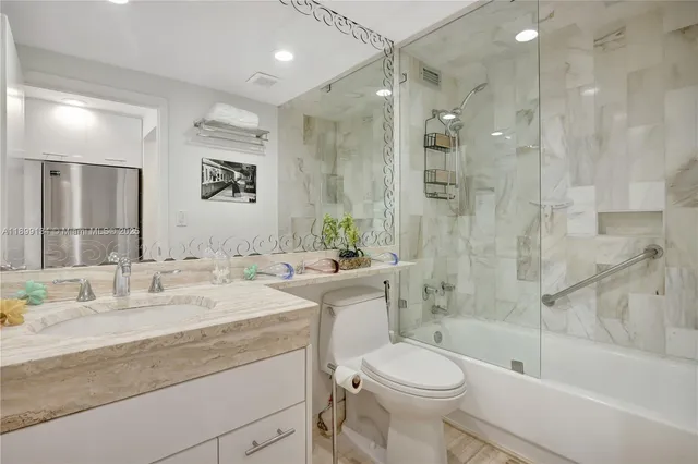 a bathroom with a granite countertop sink toilet and shower