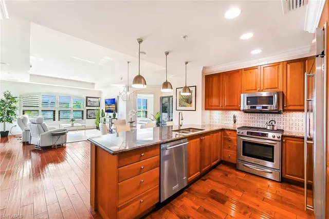 a kitchen with stainless steel appliances granite countertop a stove top oven and sink