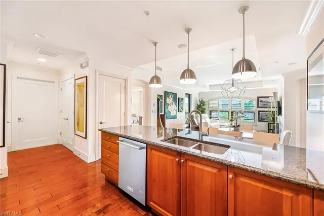 a kitchen with stainless steel appliances granite countertop a sink and wooden floor
