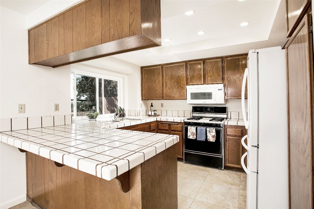 1980 Paseo Del Rey Vista, CA 92084 - Photo 7 of 25 a kitchen with stainless steel appliances granite countertop a stove top oven a sink and a refrigerator