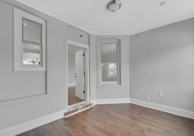 an empty room with windows and closet