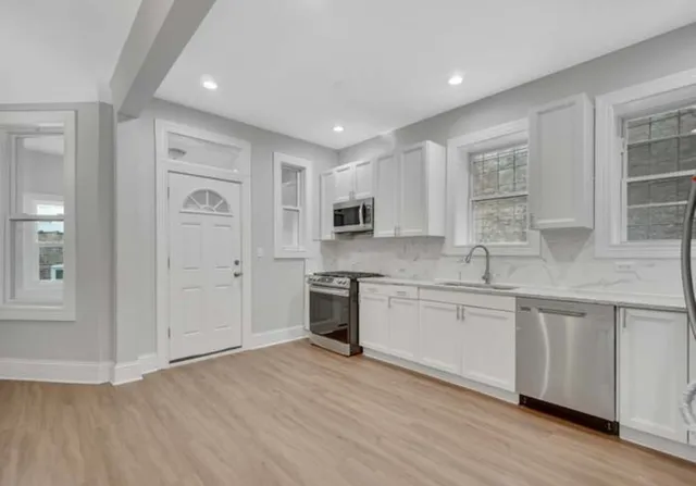 a large kitchen with stainless steel appliances granite countertop a stove and a sink