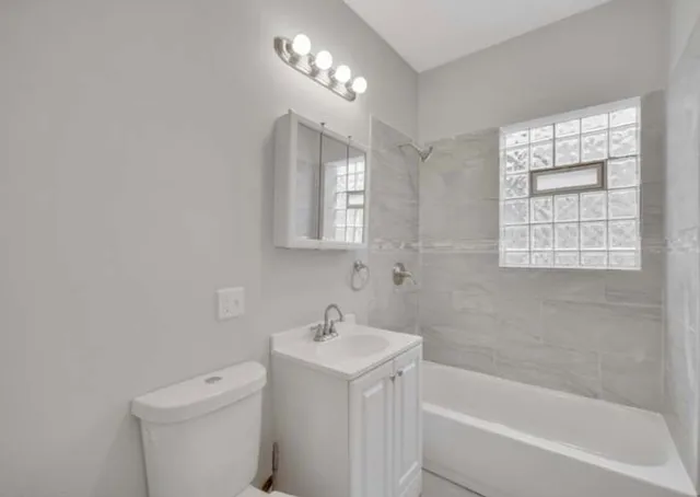 a bathroom with a sink toilet vanity and bathtub
