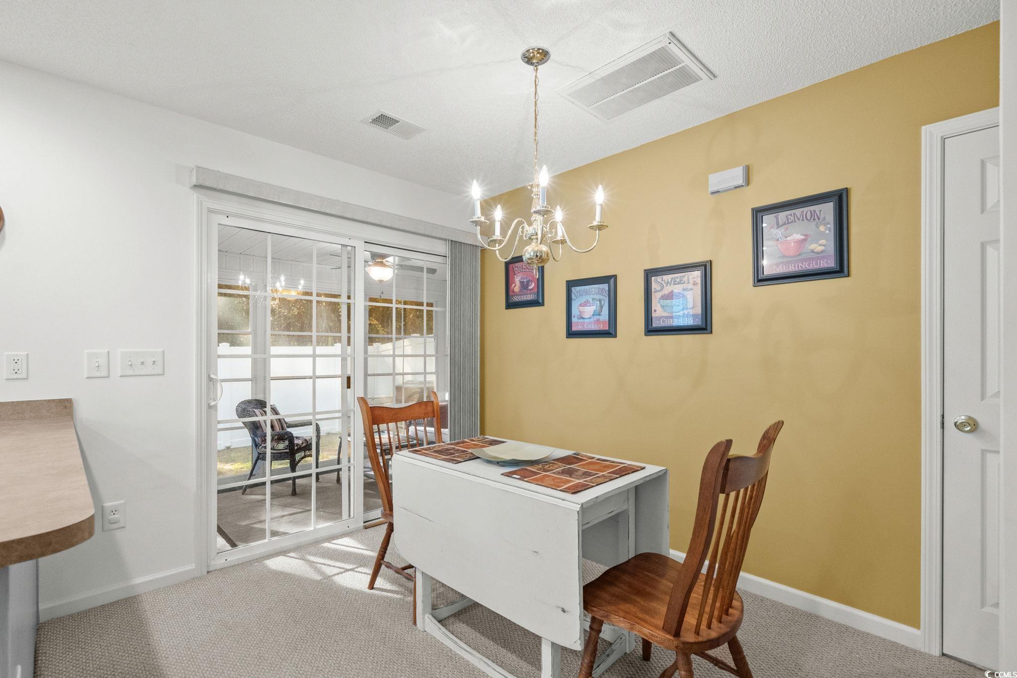 399 Seabert Road, Unit 209 Myrtle Beach, SC 29579 - Photo 12 of 40 Dining space featuring light colored carpet and a chandelier