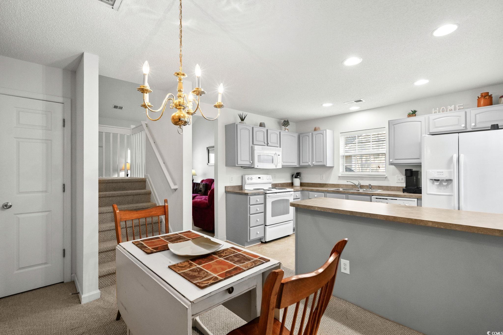 399 Seabert Road, Unit 209 Myrtle Beach, SC 29579 - Photo 13 of 40 Kitchen featuring gray cabinets, white appliances, decorative light fixtures, recessed lighting, and a chandelier