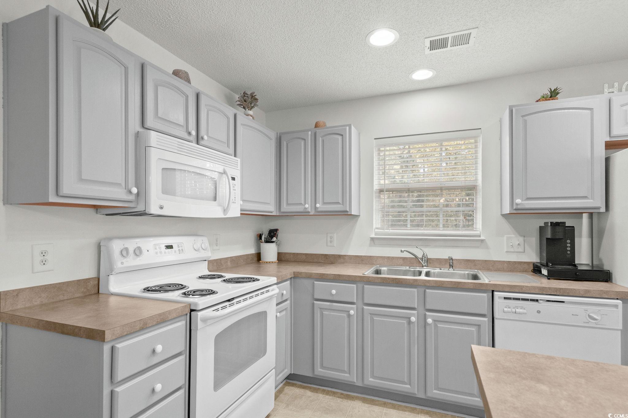 399 Seabert Road, Unit 209 Myrtle Beach, SC 29579 - Photo 16 of 40 Kitchen featuring gray cabinetry, white appliances, a textured ceiling, recessed lighting, and light countertops