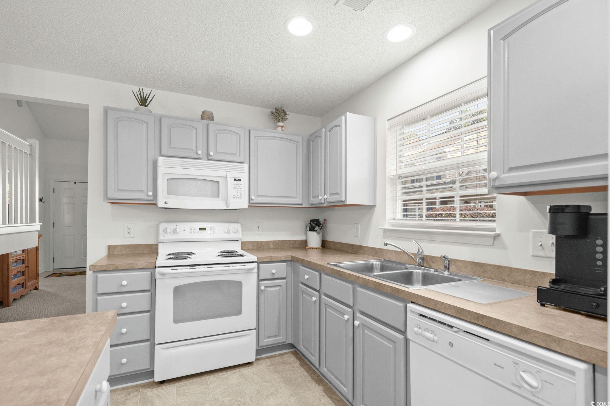 399 Seabert Road, Unit 209 Myrtle Beach, SC 29579 - Photo 17 of 40 Kitchen with gray cabinets, white appliances, light countertops, a textured ceiling, and recessed lighting